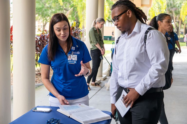 Saint Leo collaborates with Moffitt Cancer Center Student speaking with a Moffitt employee at a table.