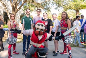 Students posting with Bucs cheerleaders and mascot.