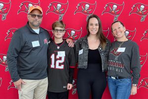 Alumni photo op at Bucs training facility tour alumni event.
